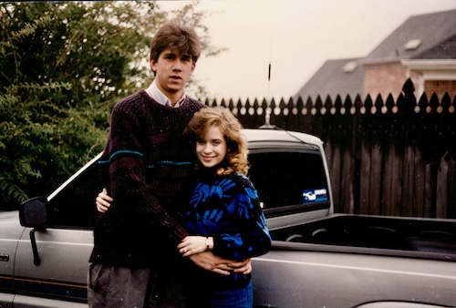 Man and woman standing alongside pickup truck